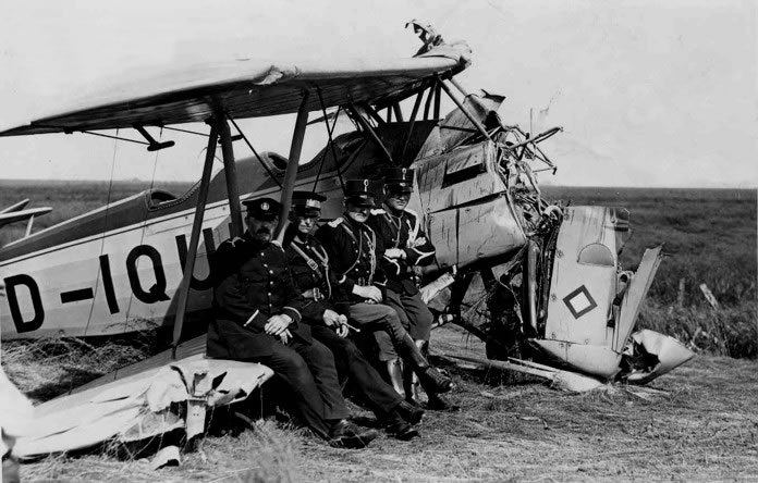 Duits militair vliegtuig (D-IQUK) maakt noodlanding in de Oostpolder onder Oude Schip, Groningen, 30 juni 1936; vlnr gemeenteveldwachter Jager, Roodeschool; rijksveldwachter Wolthuis, Uithuizermeeden; wachtmeester Jansen, Uithuizen; marechaussee Steringa, Uithuizen.